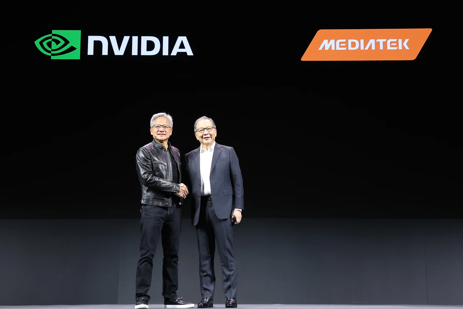 黃仁勳與蔡力行在 NVIDIA 及 MediaTek 品牌標誌前握手合影