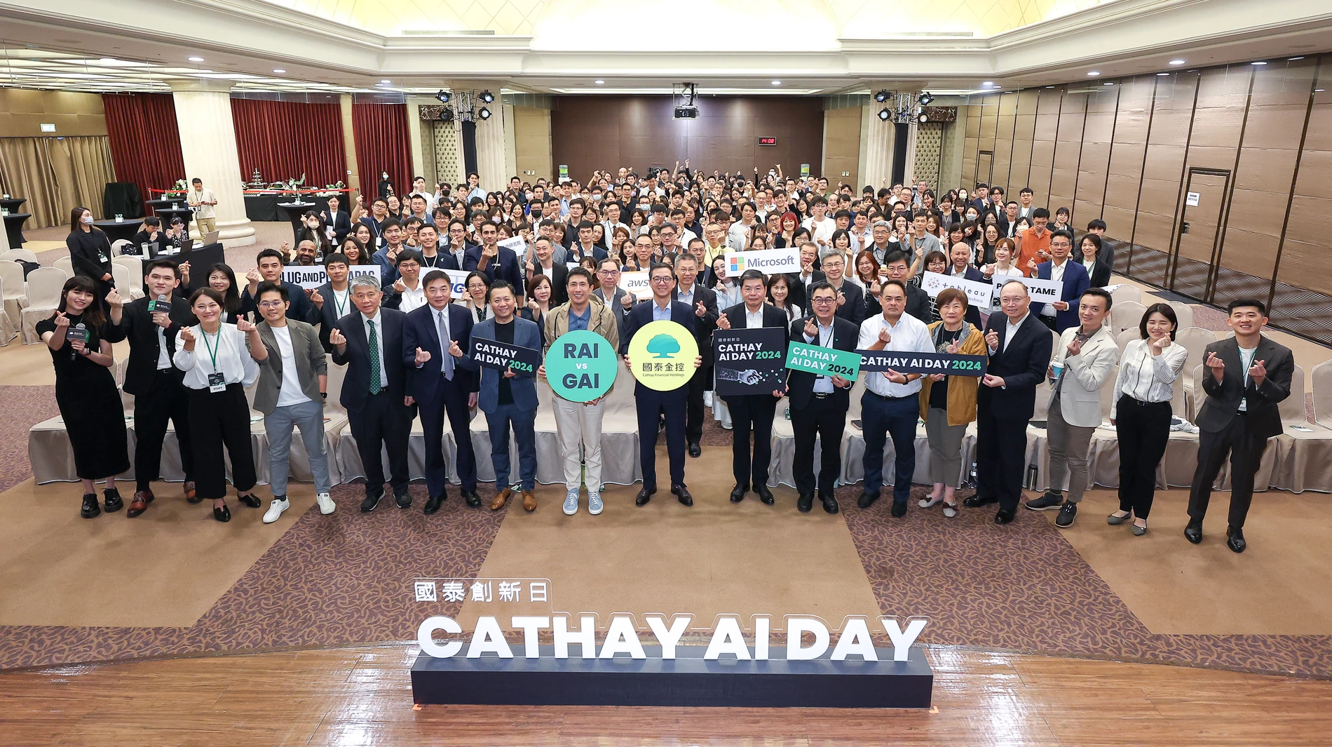 國泰金控AI Day全體參與者手持主題字牌與舞台活動字樣團體合影