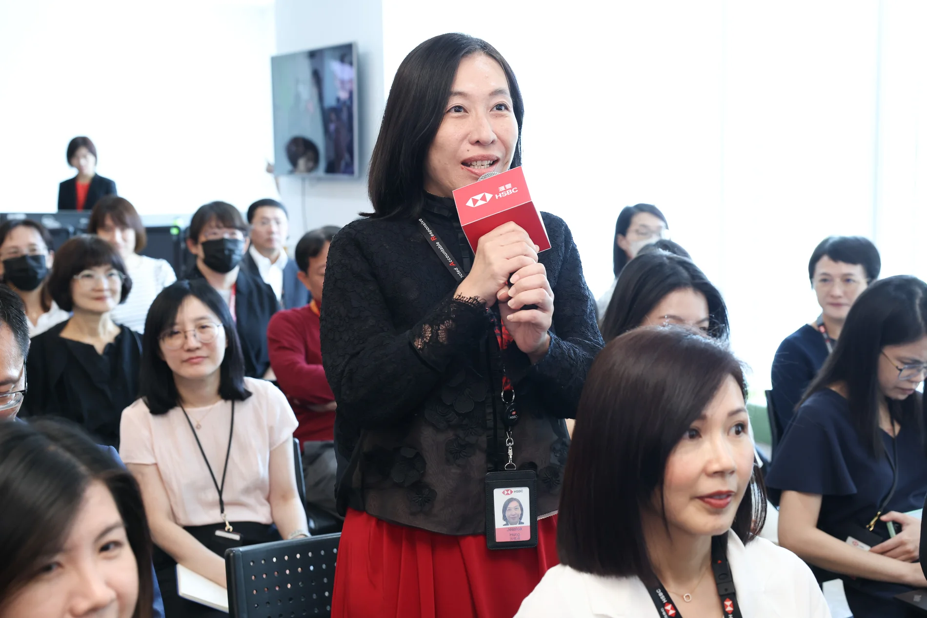 女性與會者在滙豐銀行員工大會舉麥克風提問