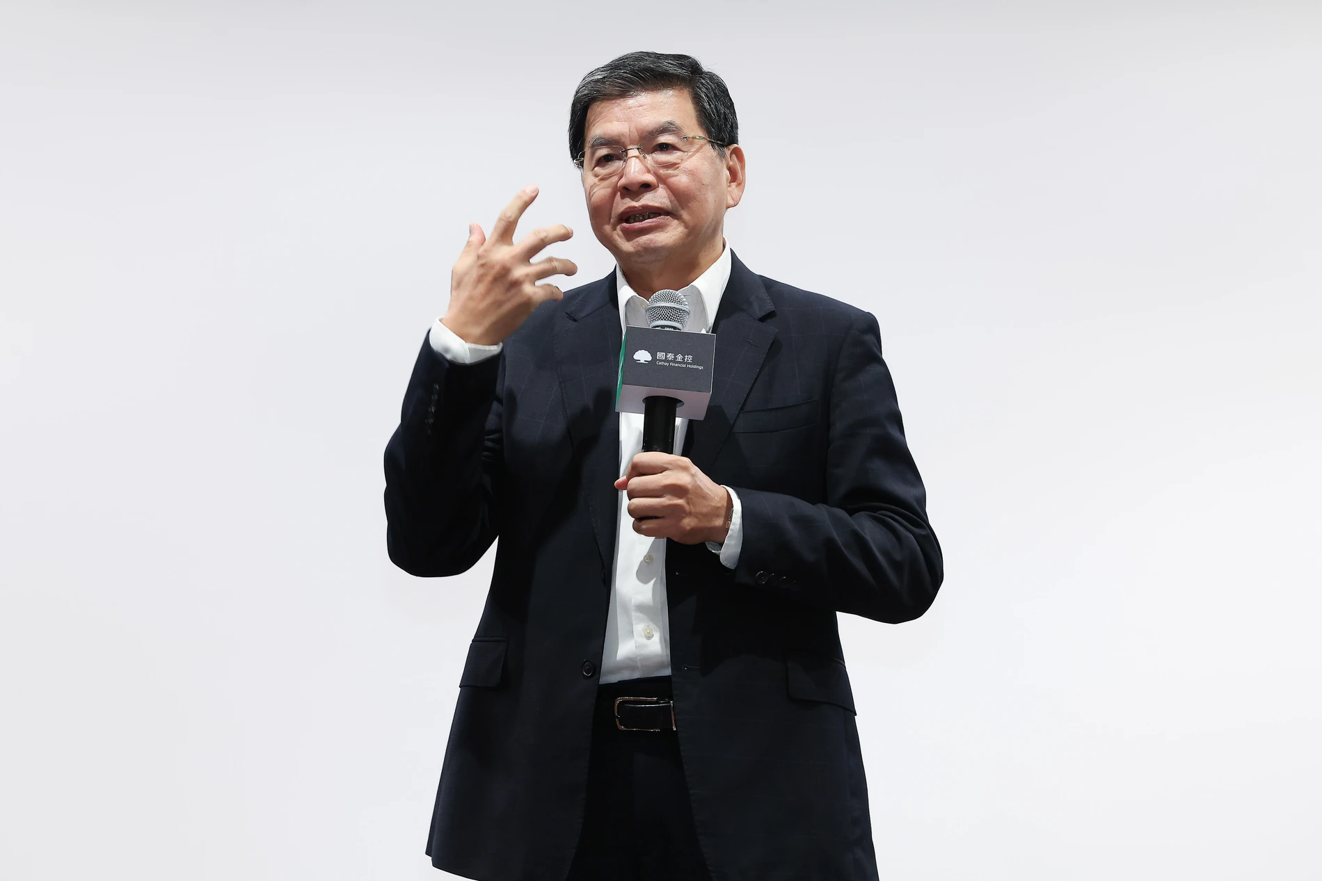 國泰金控AI Day講者手持麥克風並以手勢分享的近景