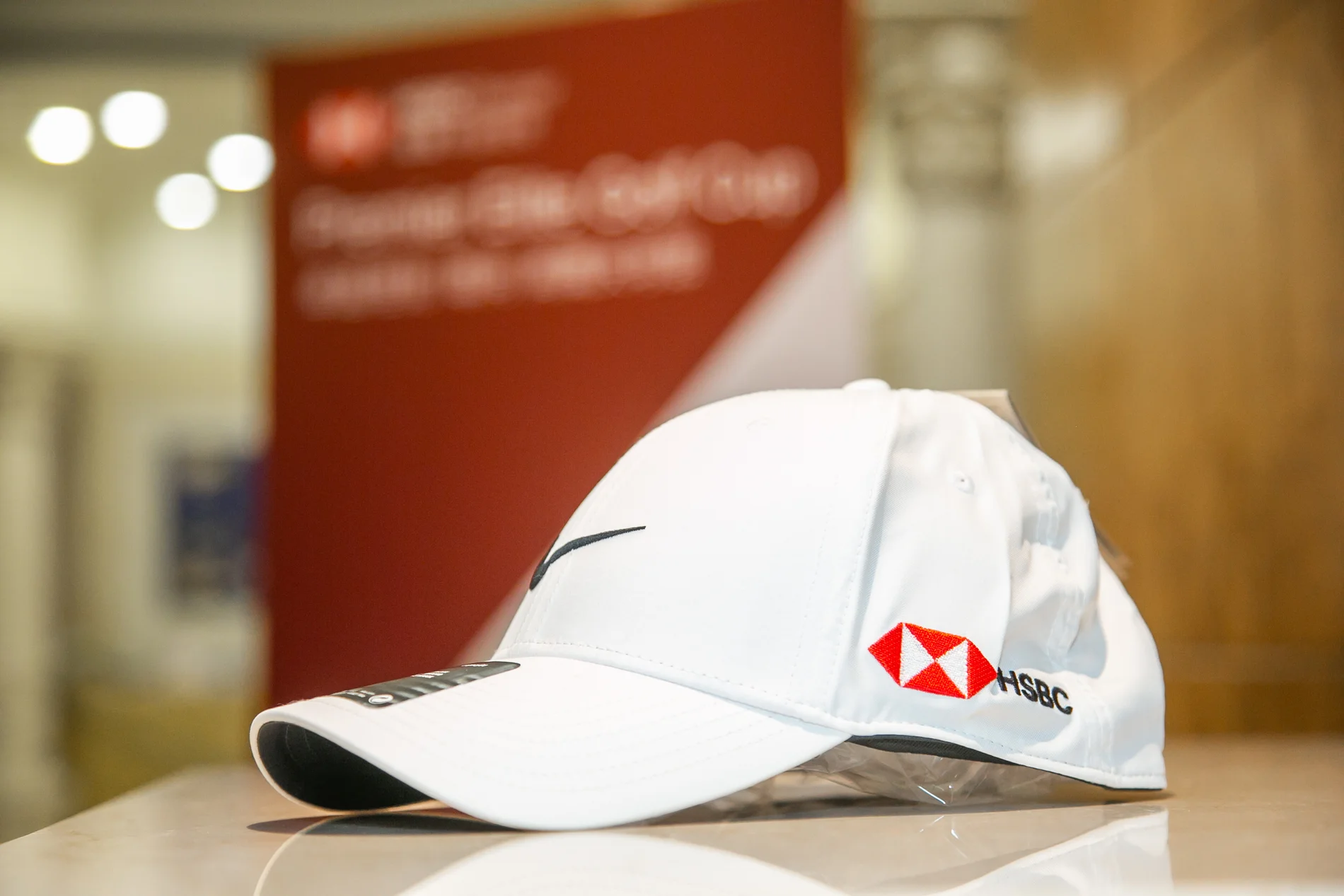 白色HSBC品牌高爾夫球帽與滙豐銀行球賽活動背板