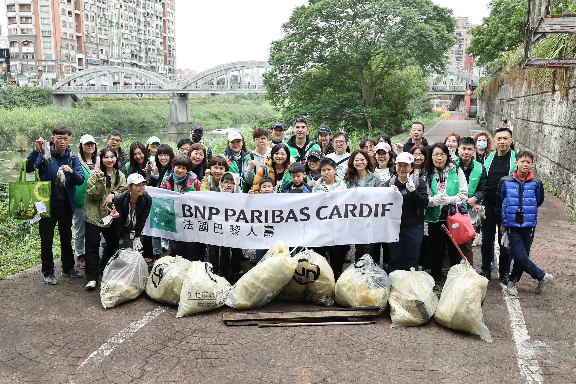 法國巴黎人壽志工手持BNP PARIBAS CARDIF品牌布條與裝袋清理成果團體合照